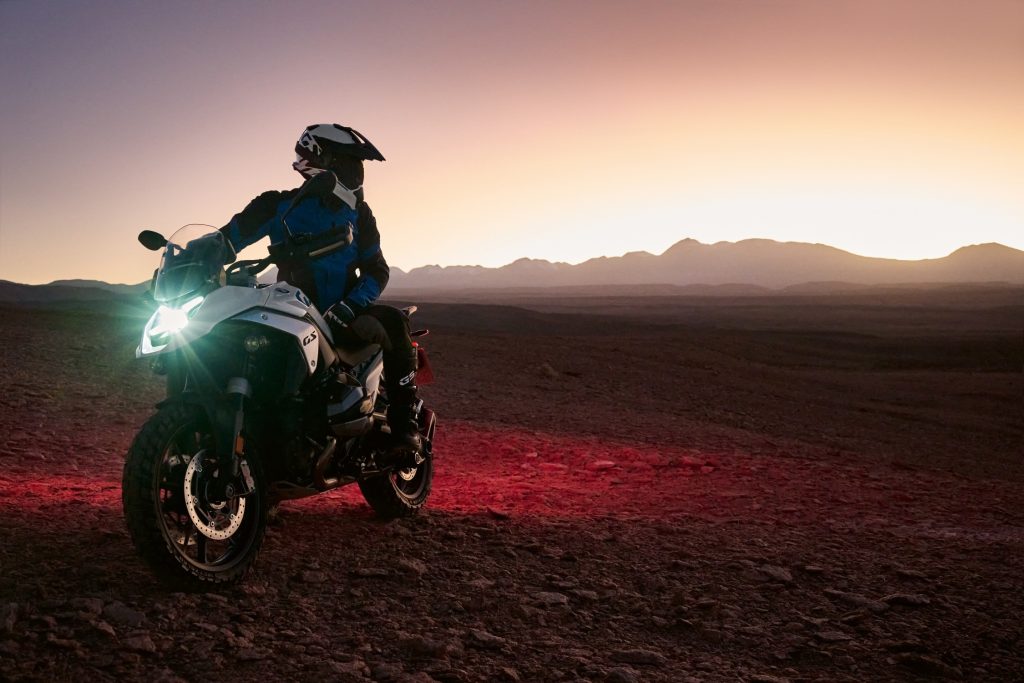 Motociclista che controlla la moto prima di partire, a illustrare la guida alla scelta dell'assicurazione moto giusta