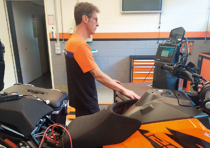 Meccanico controlla sistema anti inquinamento di una moto durante la revisione periodica obbligatoria