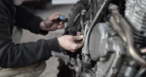Meccanico controlla una moto personalizzata in officina per verificare le modifiche legali e omologate